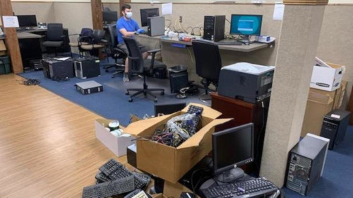 The BTS office filled with donated computers, as one worker is preparing one of the computer
