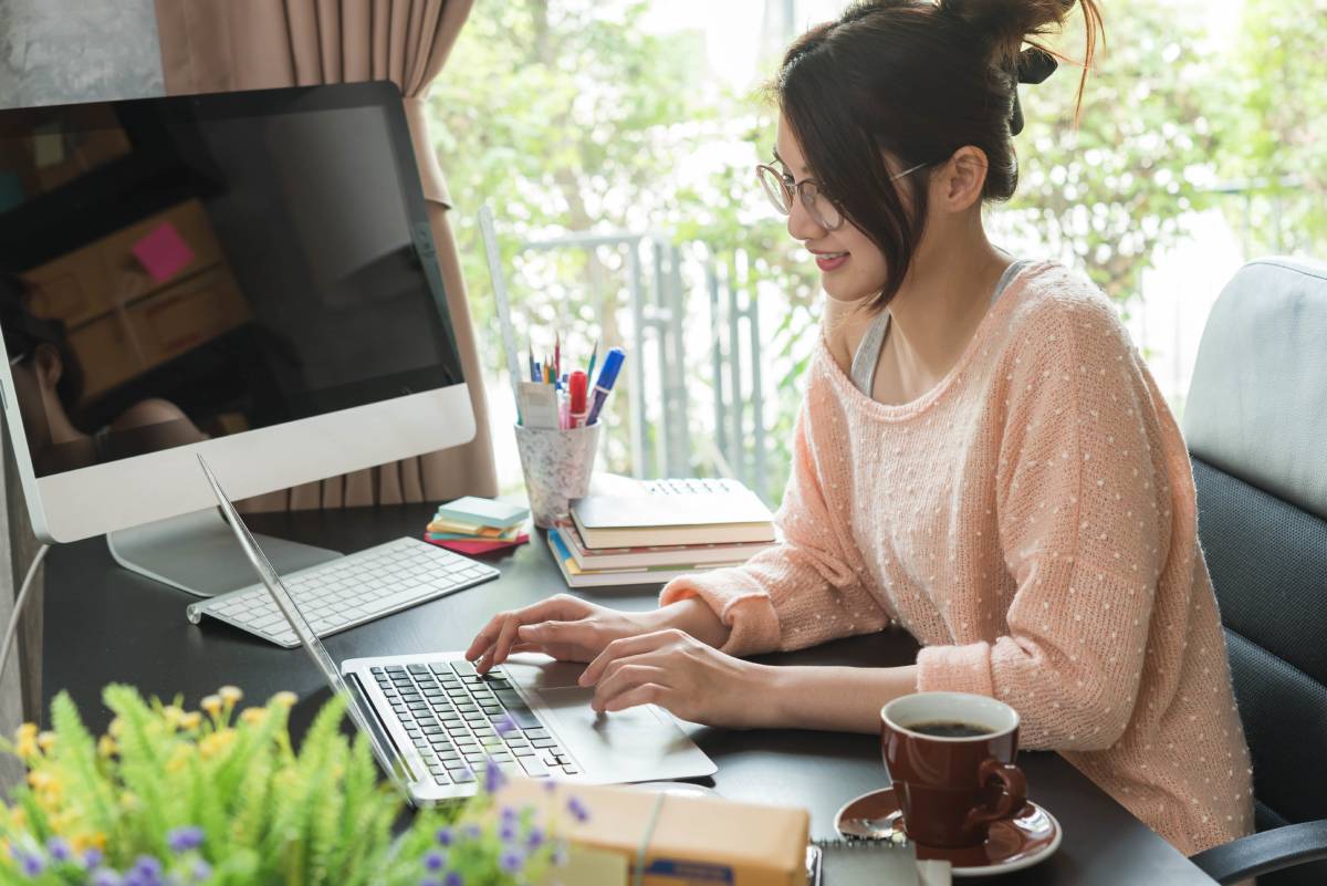 Asian lady typing on a laptop.