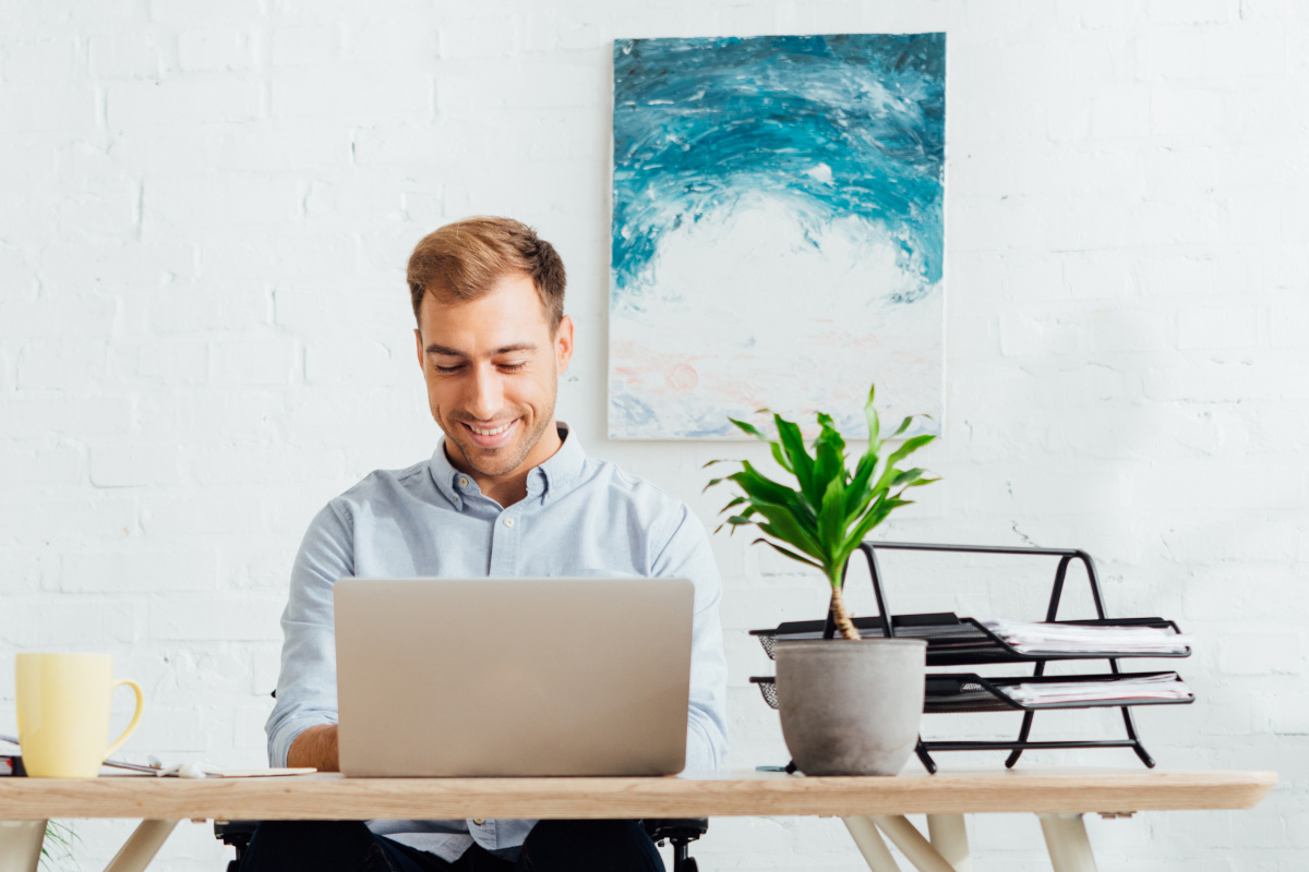 Smiling Business Man Using Laptop at Desk