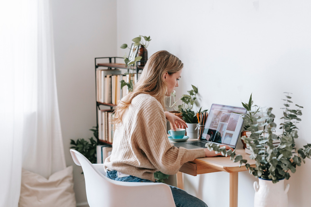 Freelancer working at home on a laptop, with photos on the screen