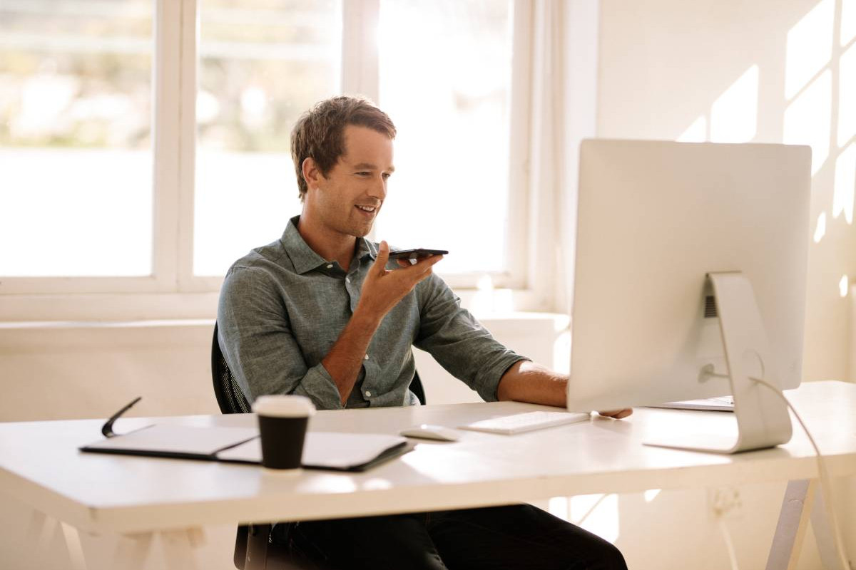 Man sitting in home office talking into a mobile phone