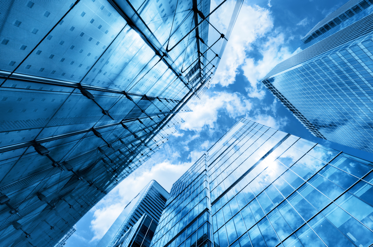 Vertical view from the ground of tall buildings and a blue sky
