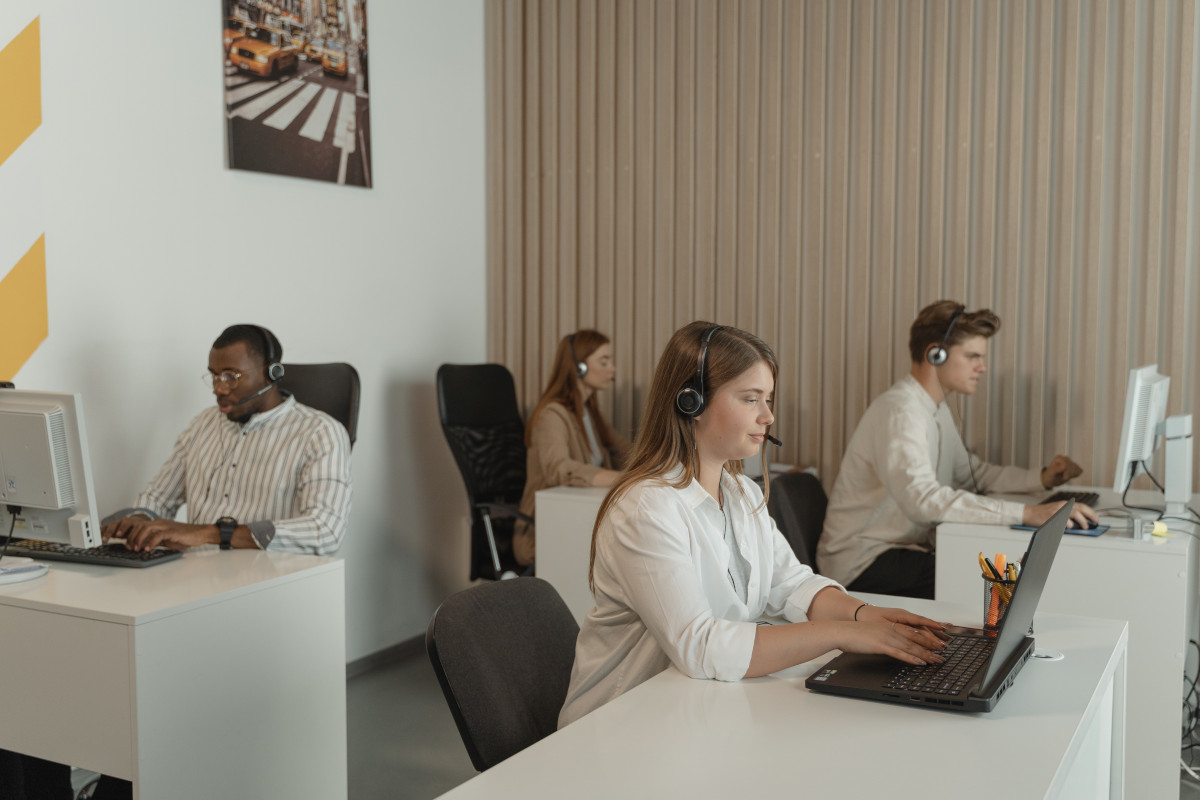 Four call center employees working in the same room at different desks