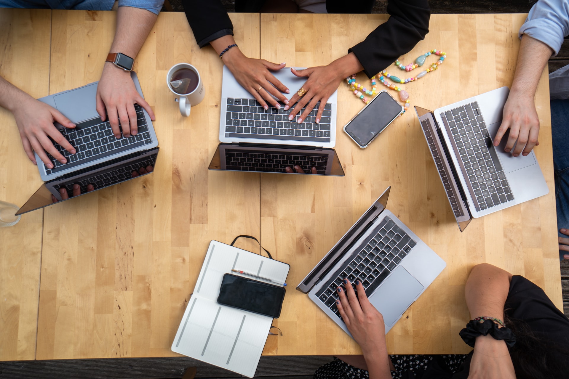 An overhead shot of people working on laptops