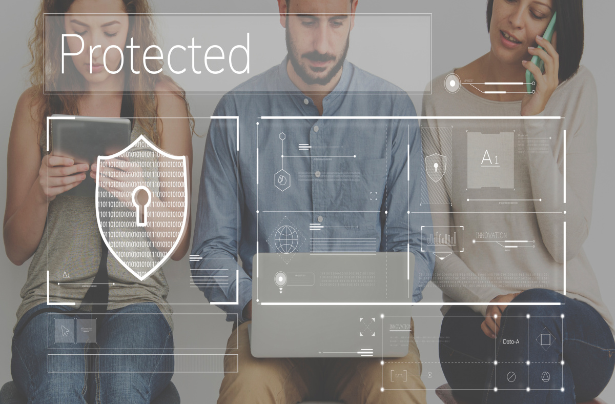 Three People Working on Different Devices Protected with Managed Security