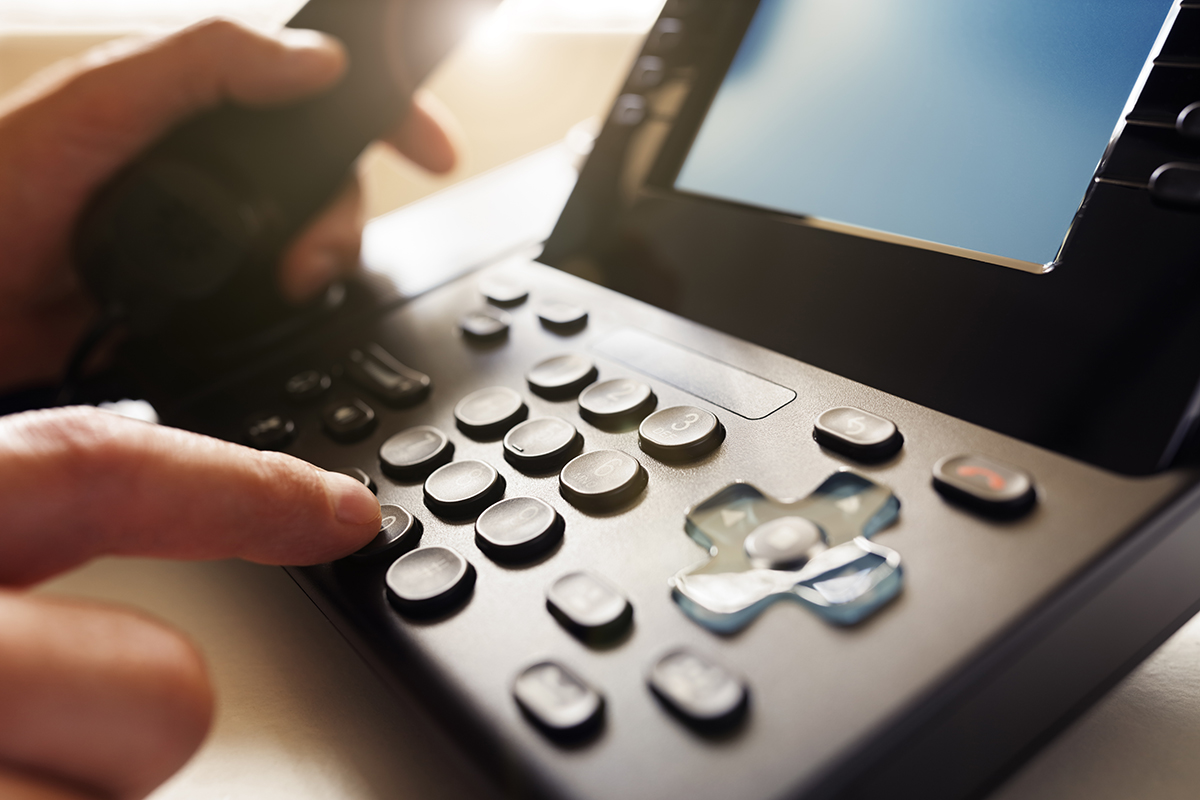 User dialing numbers on a phone.