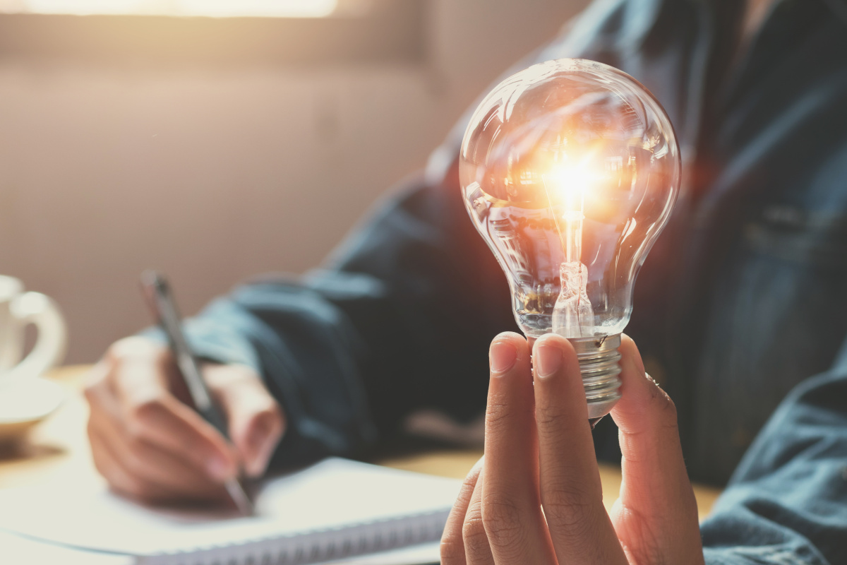 Man working and holding lit light bulb