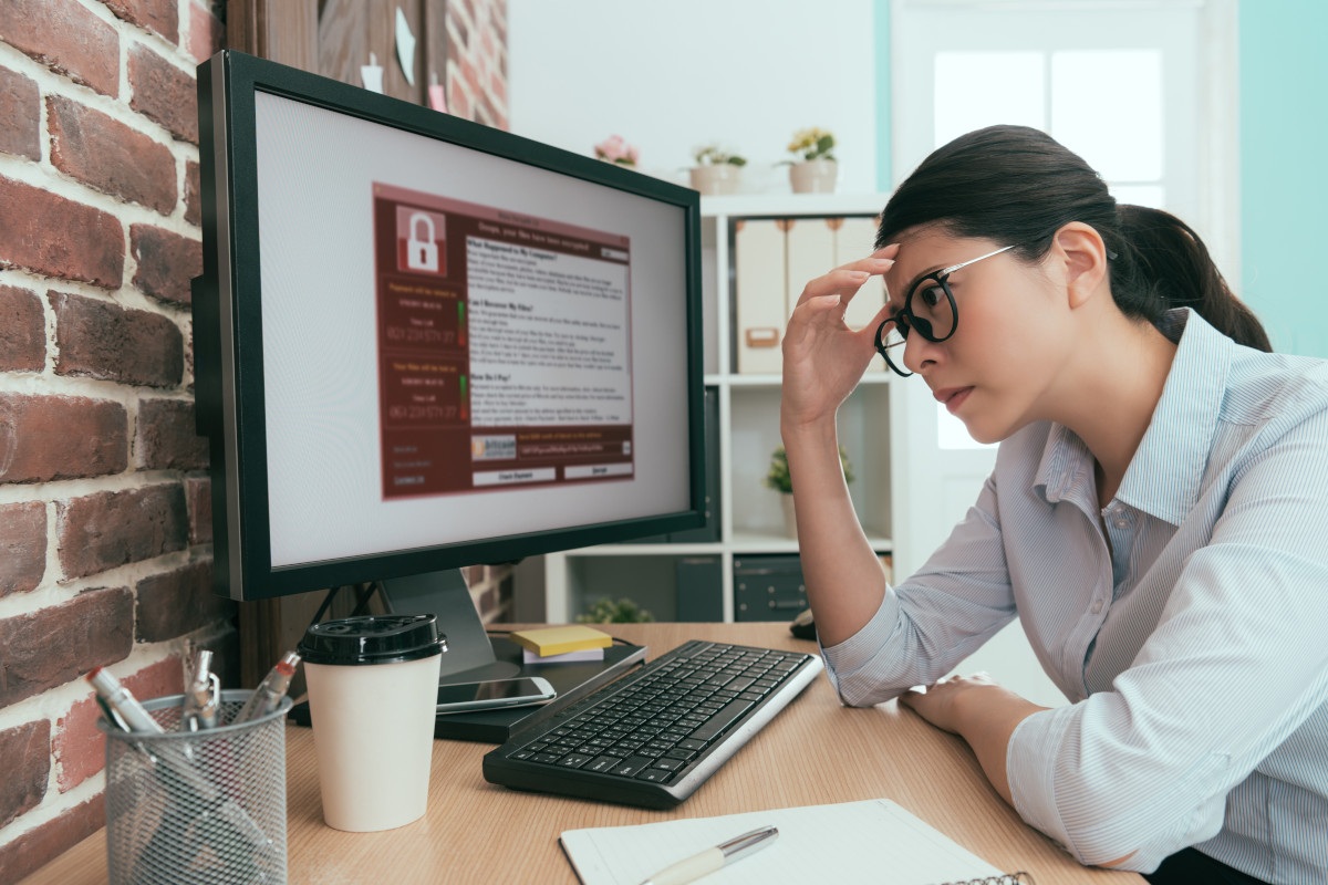 A person displaying distress over a security message on their work computer screen