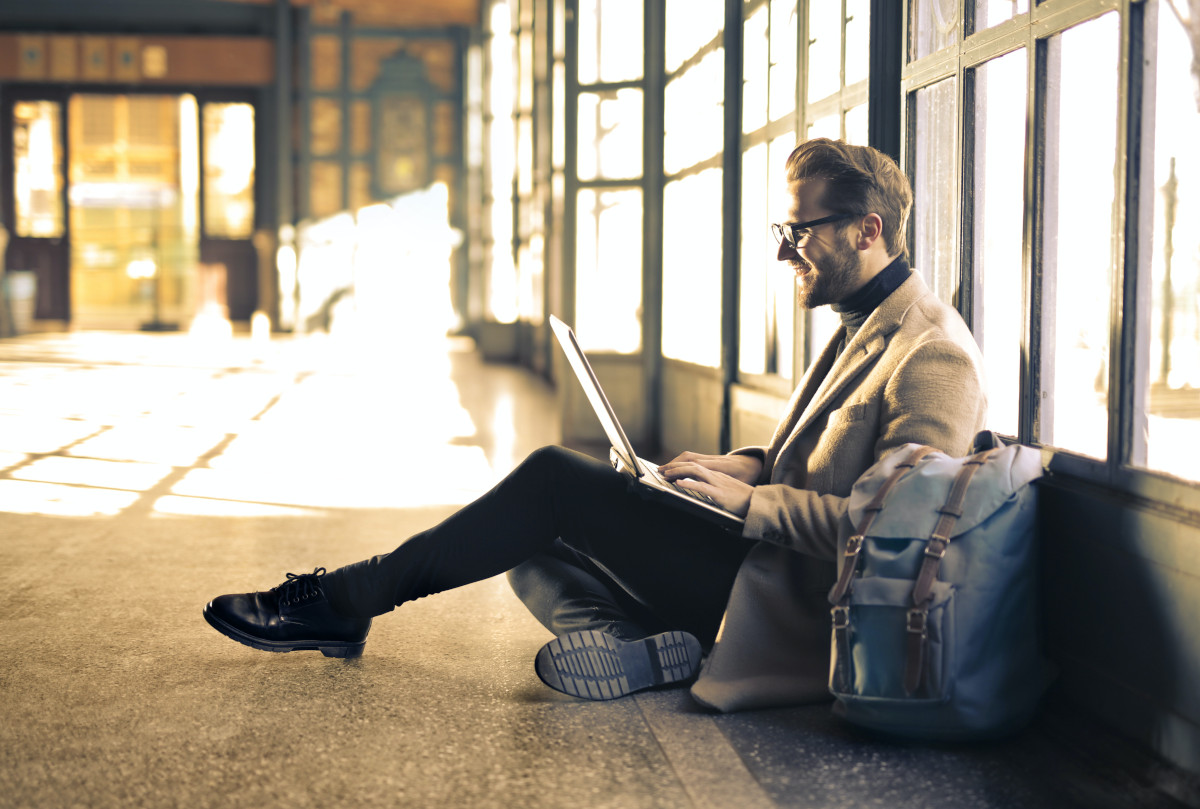 A man wearing a gray blazer and working remotely