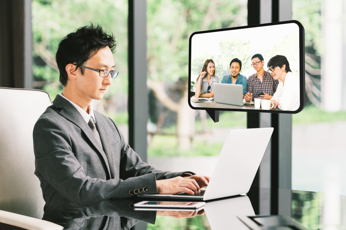 A man working from home while video conferencing with colleagues