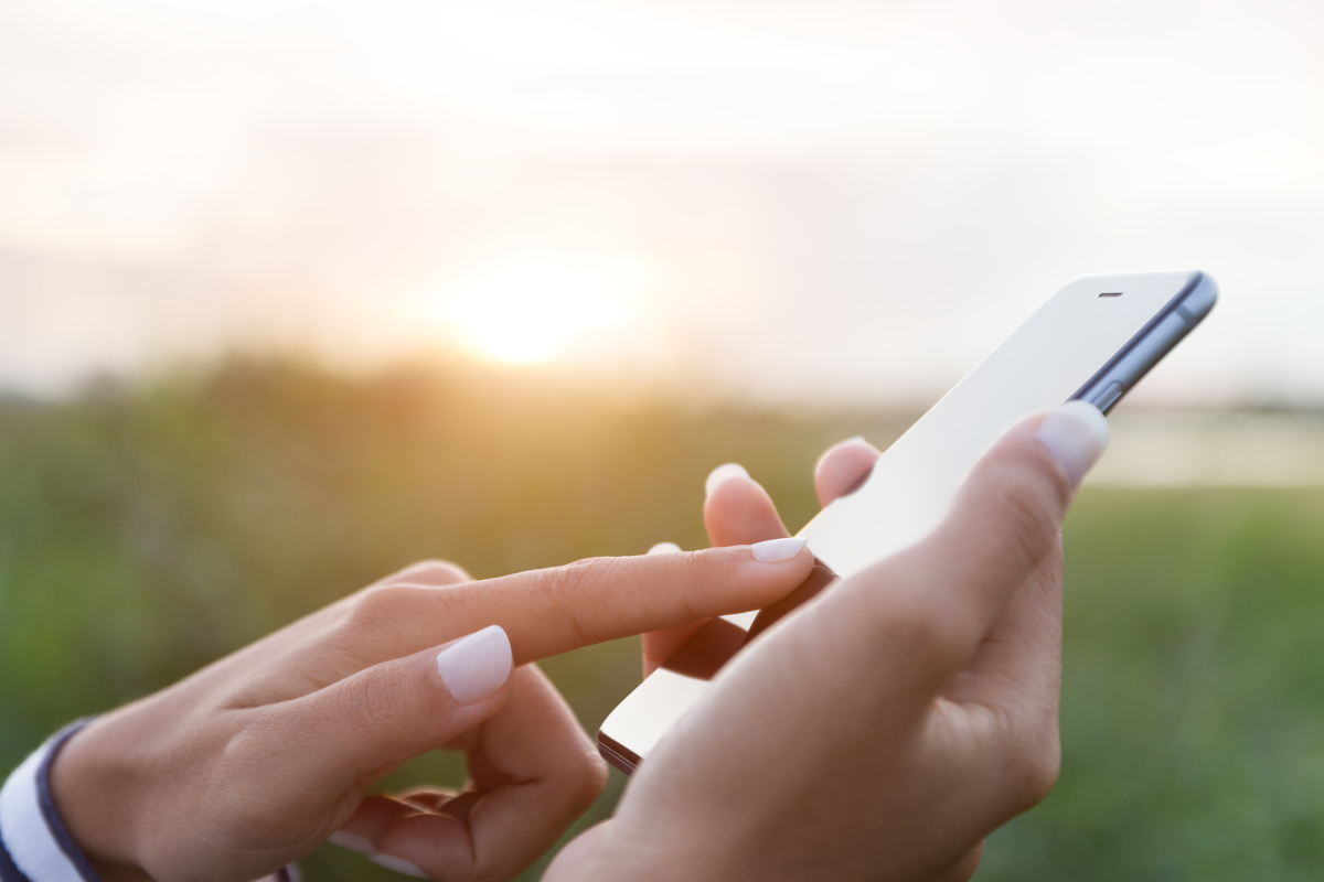 A hand dialing a mobile phone