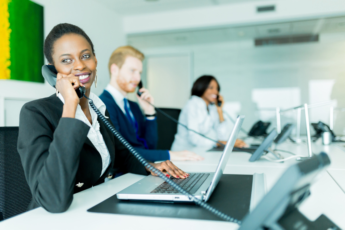 A group of employees each answering their office phones