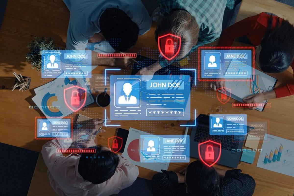 Team working at a table with digital security locks and user account panels projected above them.